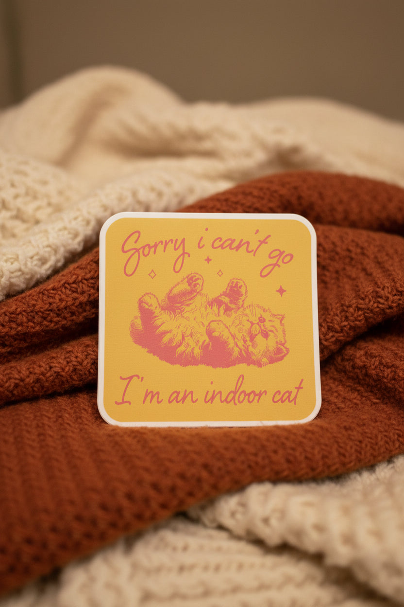 Sticker with text 'Sorry I can't go, I'm an indoor cat' held over a checkered background