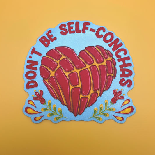 A die-cut sticker featuring a stylized red and yellow marbled heart on a light blue background, with the text 'DON'T BE SELF-CONCHAS' in red around the top and decorative red and yellow floral elements near the bottom, shown on a solid yellow background.