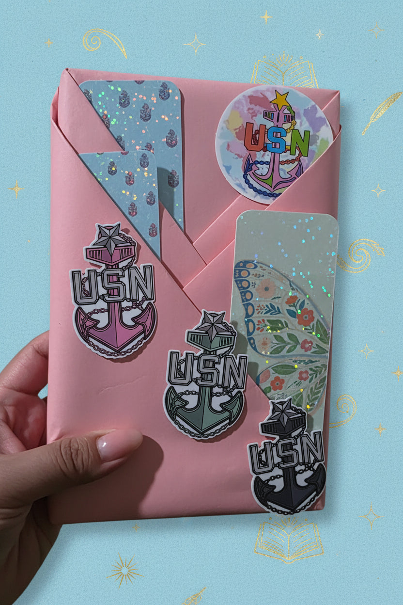 Book wrapped in pink craft paper with colorful stickers held by a hand on a textured surface